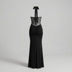 Black evening gown with sheer neckline on a light gray background