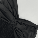 Close-up of black fabric with a knot on a white background