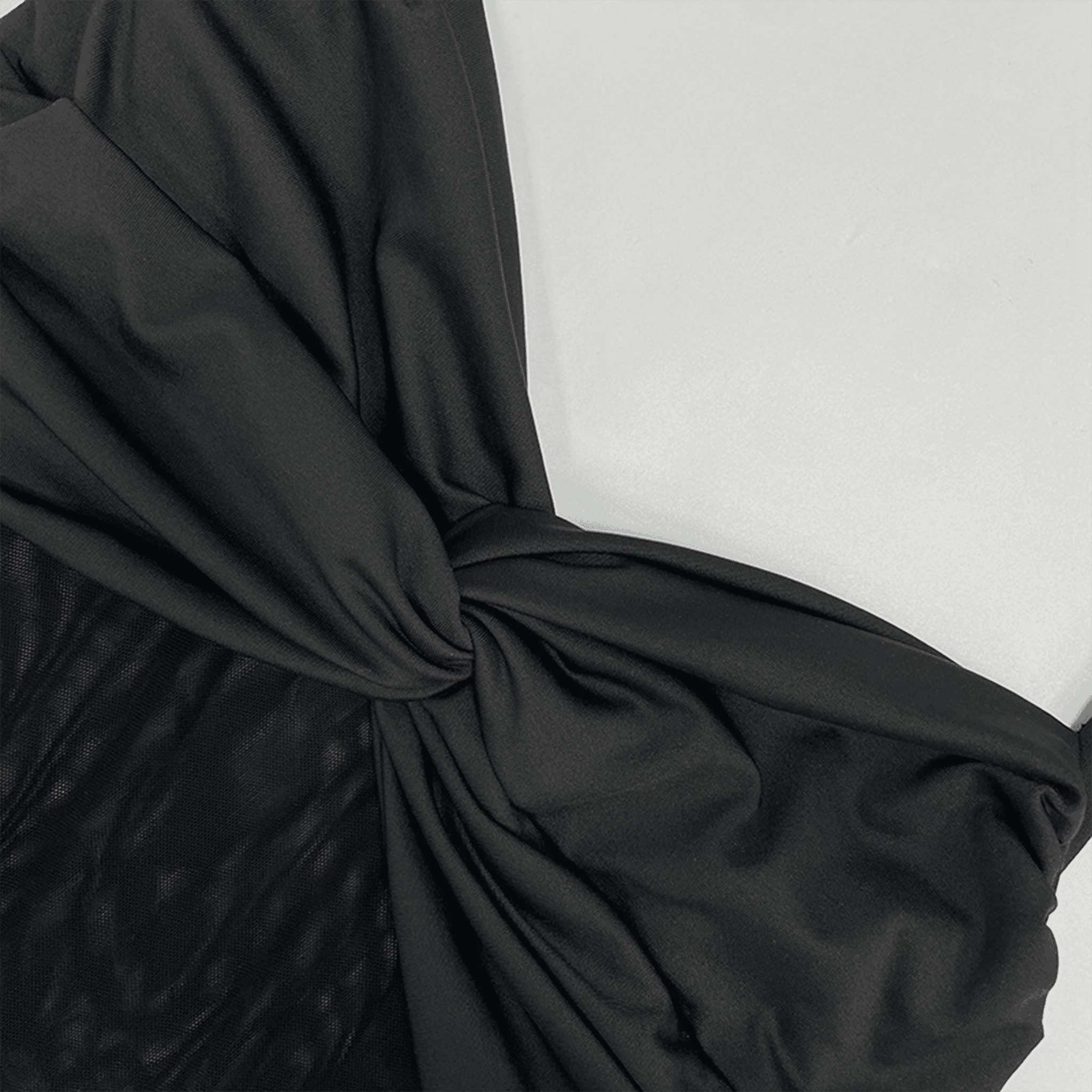 Close-up of black fabric with a knot on a white background