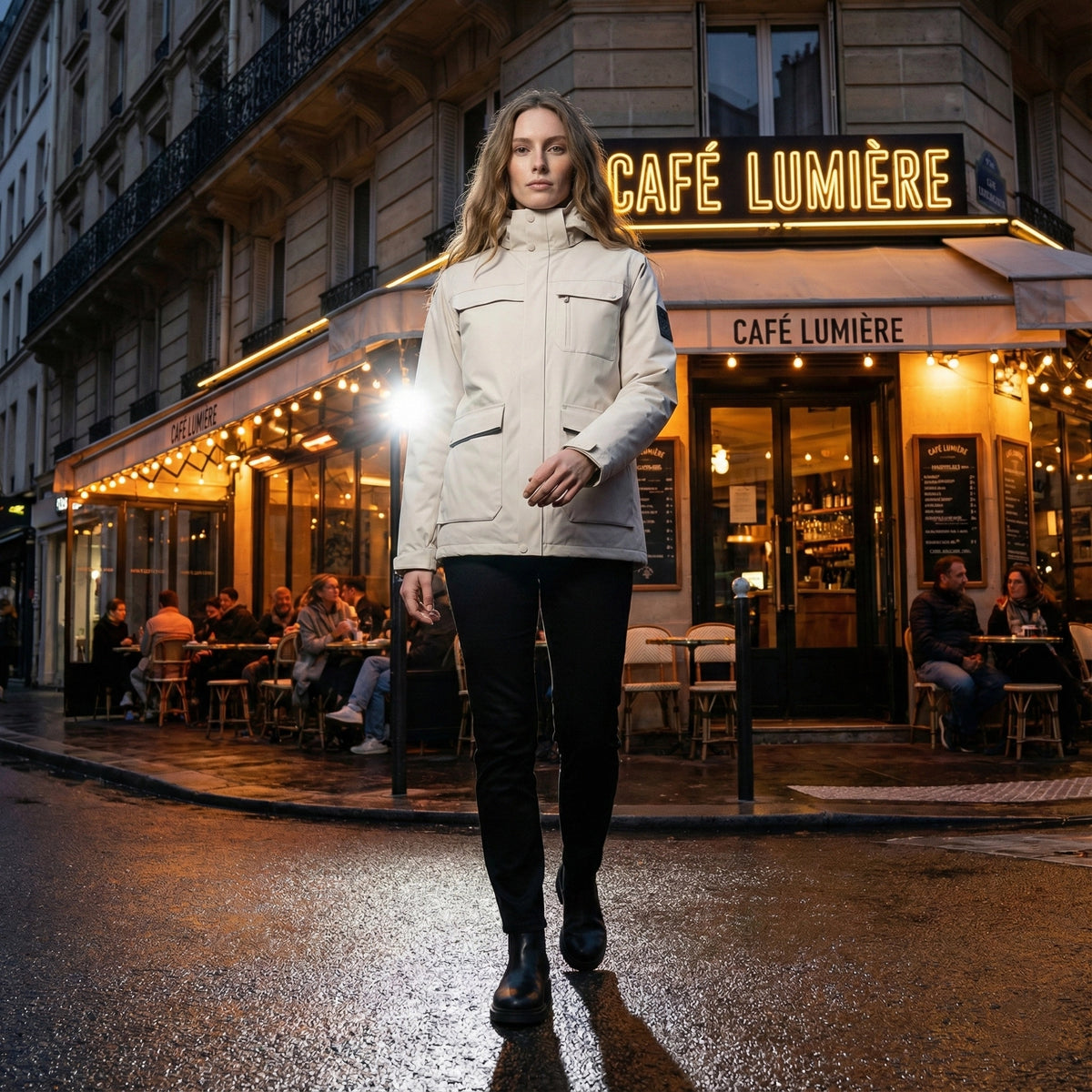 Woman walking on a street in front of Café Lumière at night.