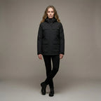 Woman wearing a black jacket against a neutral background