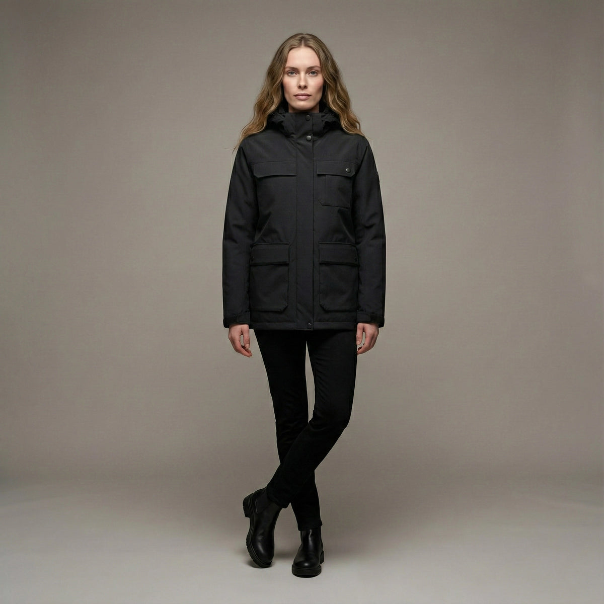 Woman wearing a black jacket against a neutral background