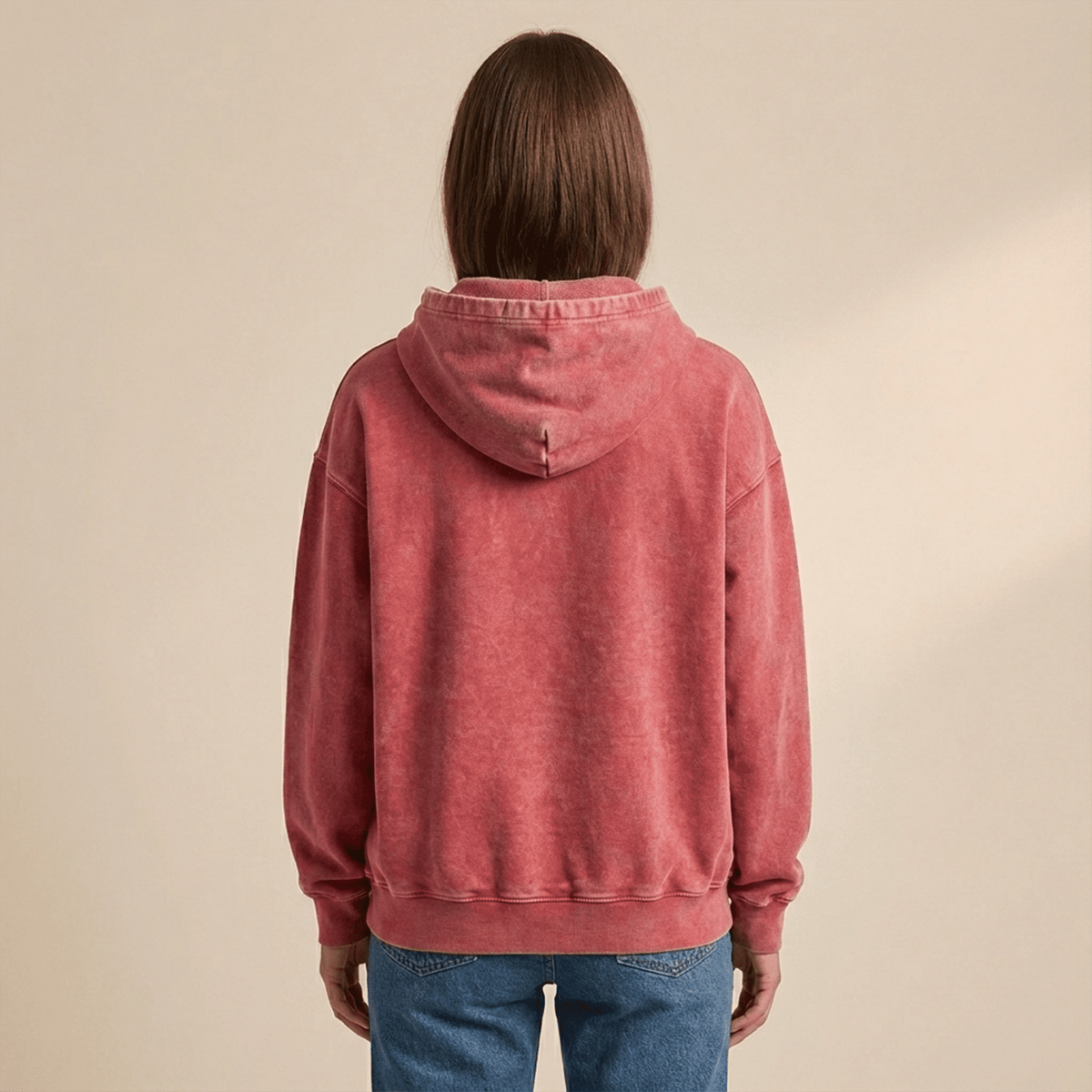 Person wearing a red hoodie from behind on a beige background