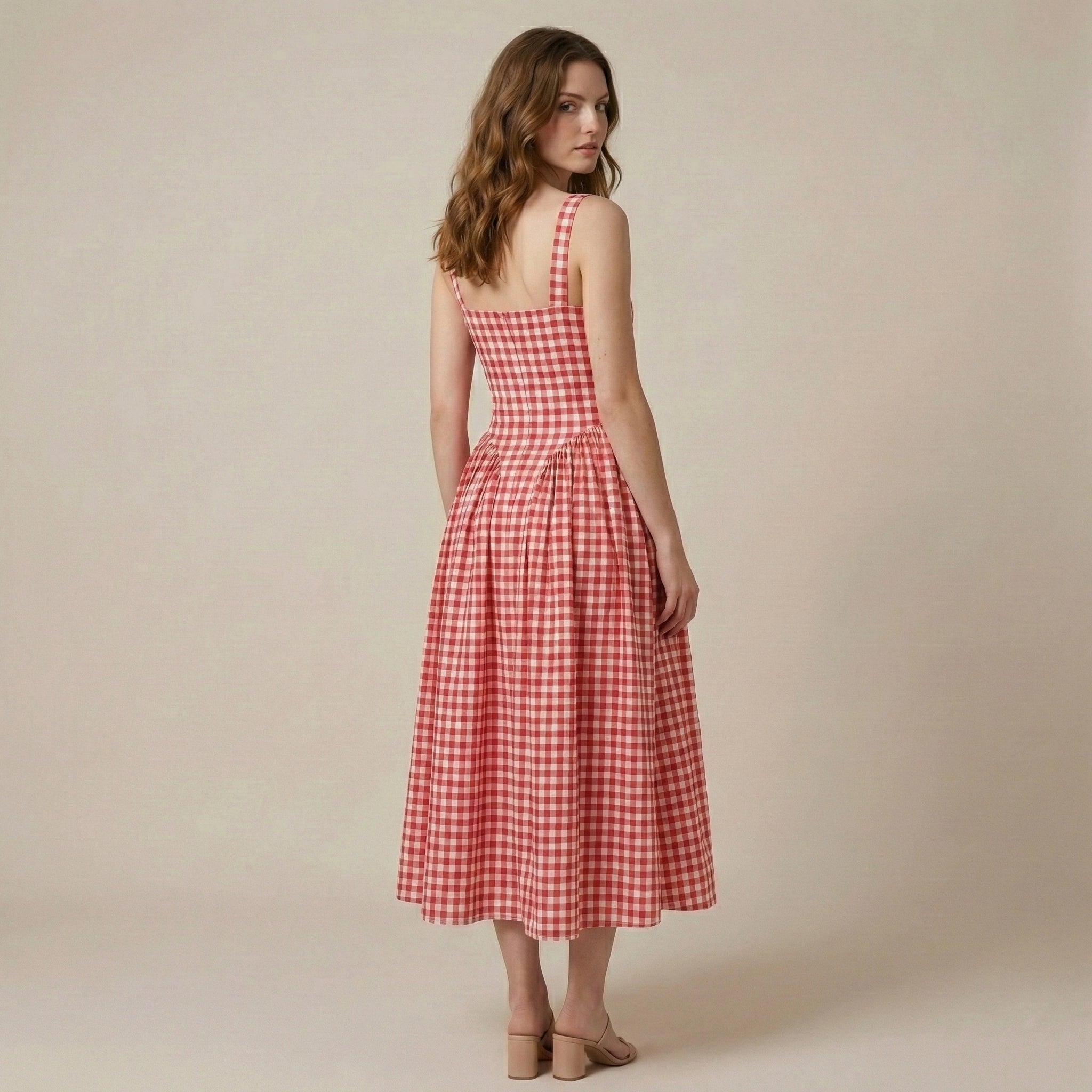 Woman wearing a red and white checkered dress against a beige background