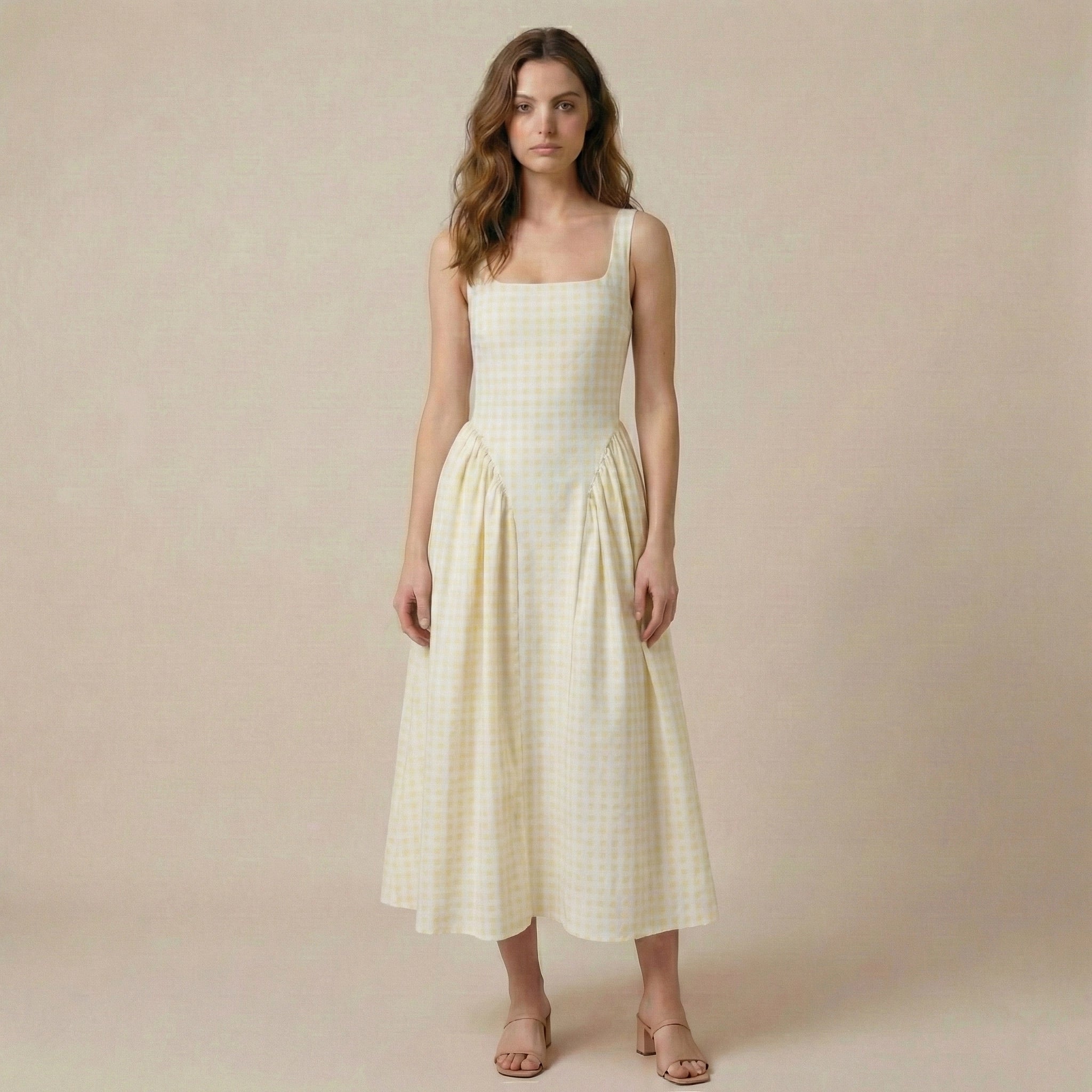 Woman wearing a light yellow checkered dress against a beige background