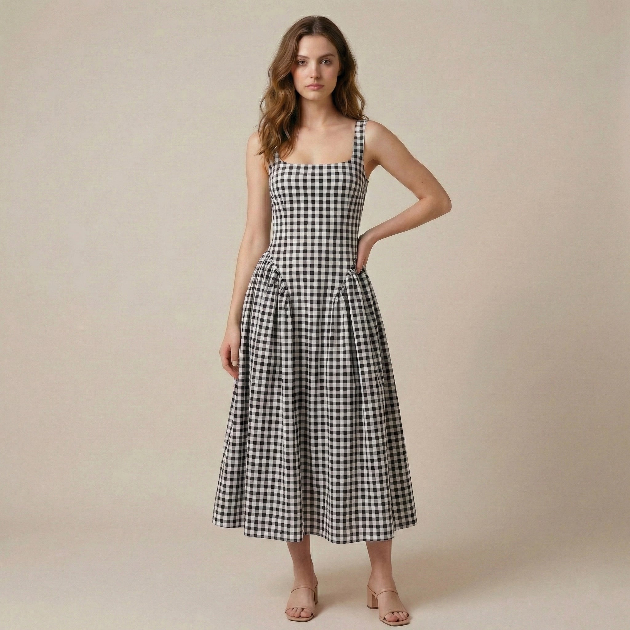 Woman wearing a black and white checkered dress against a beige background