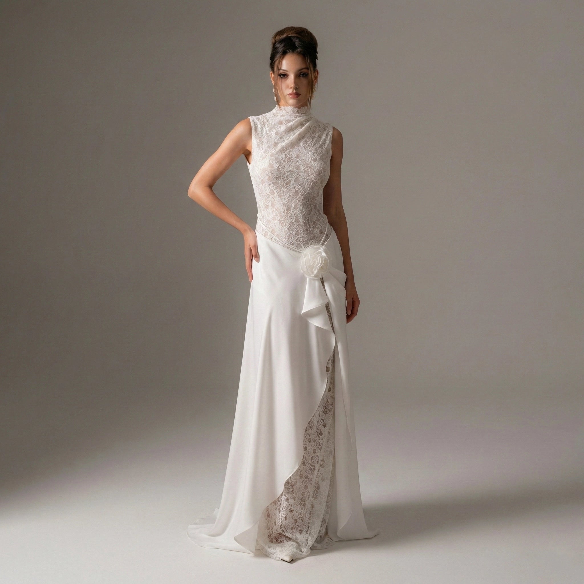 Woman wearing a white wedding dress with lace details on a plain background