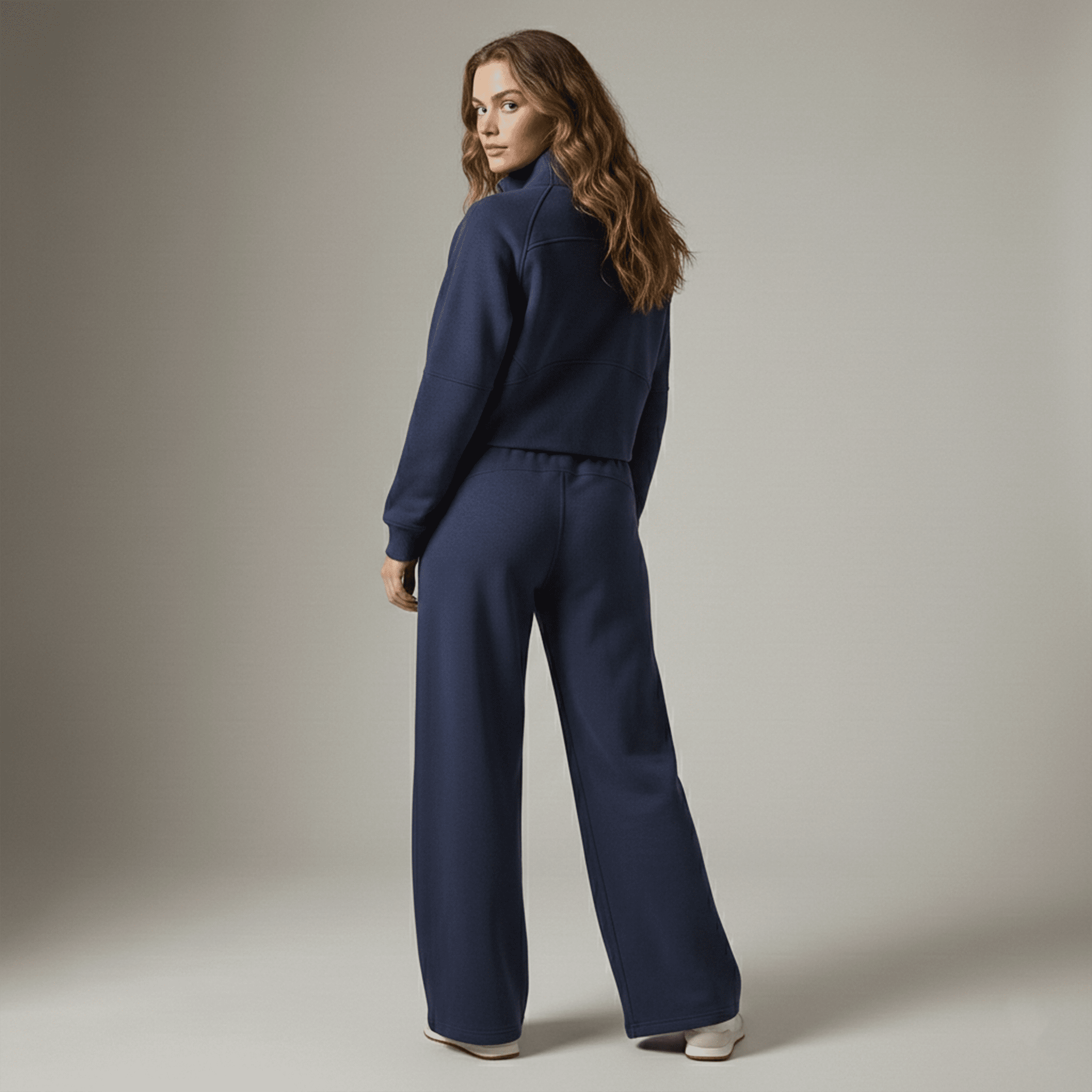 Woman wearing a navy blue outfit against a neutral background