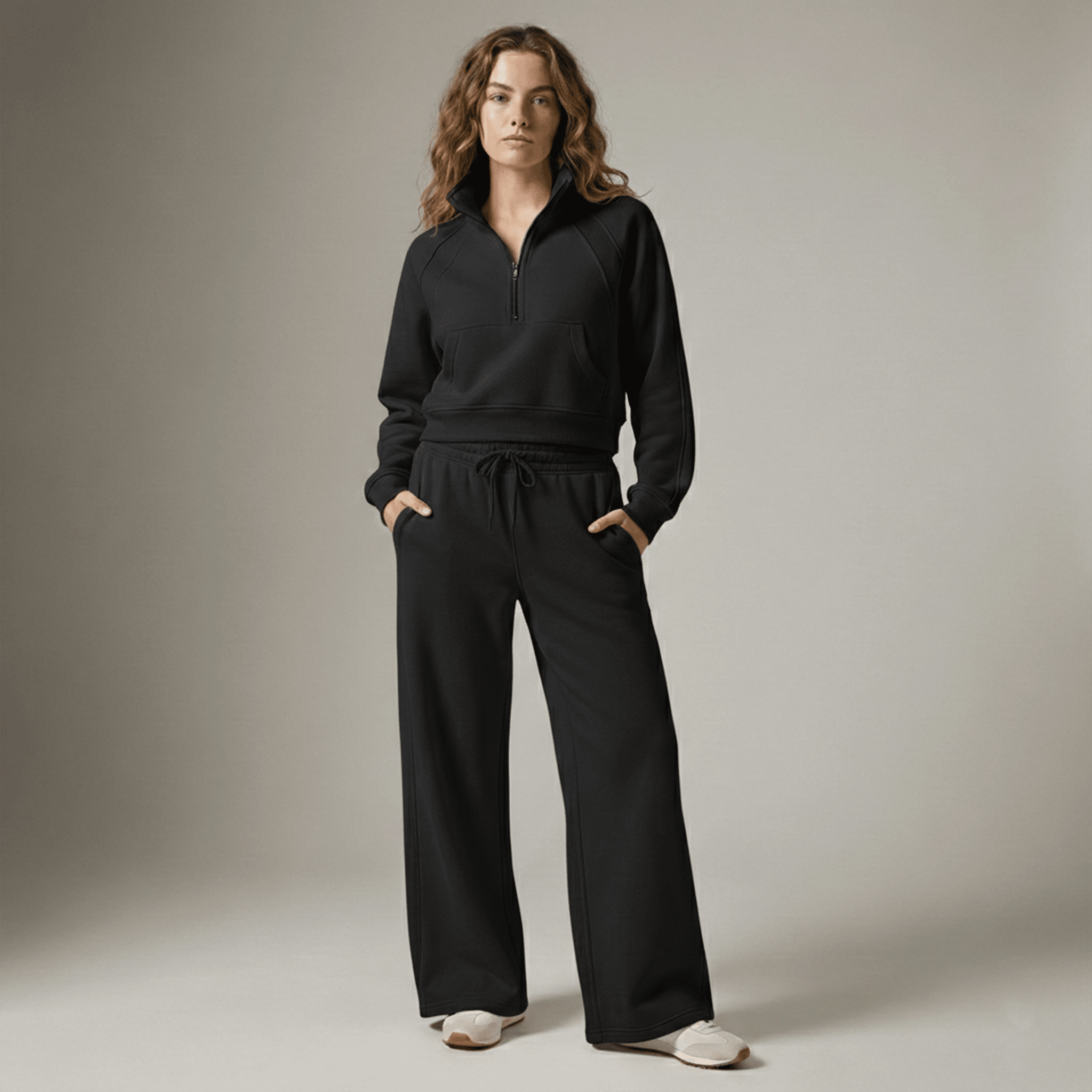 Woman wearing a black tracksuit against a neutral background