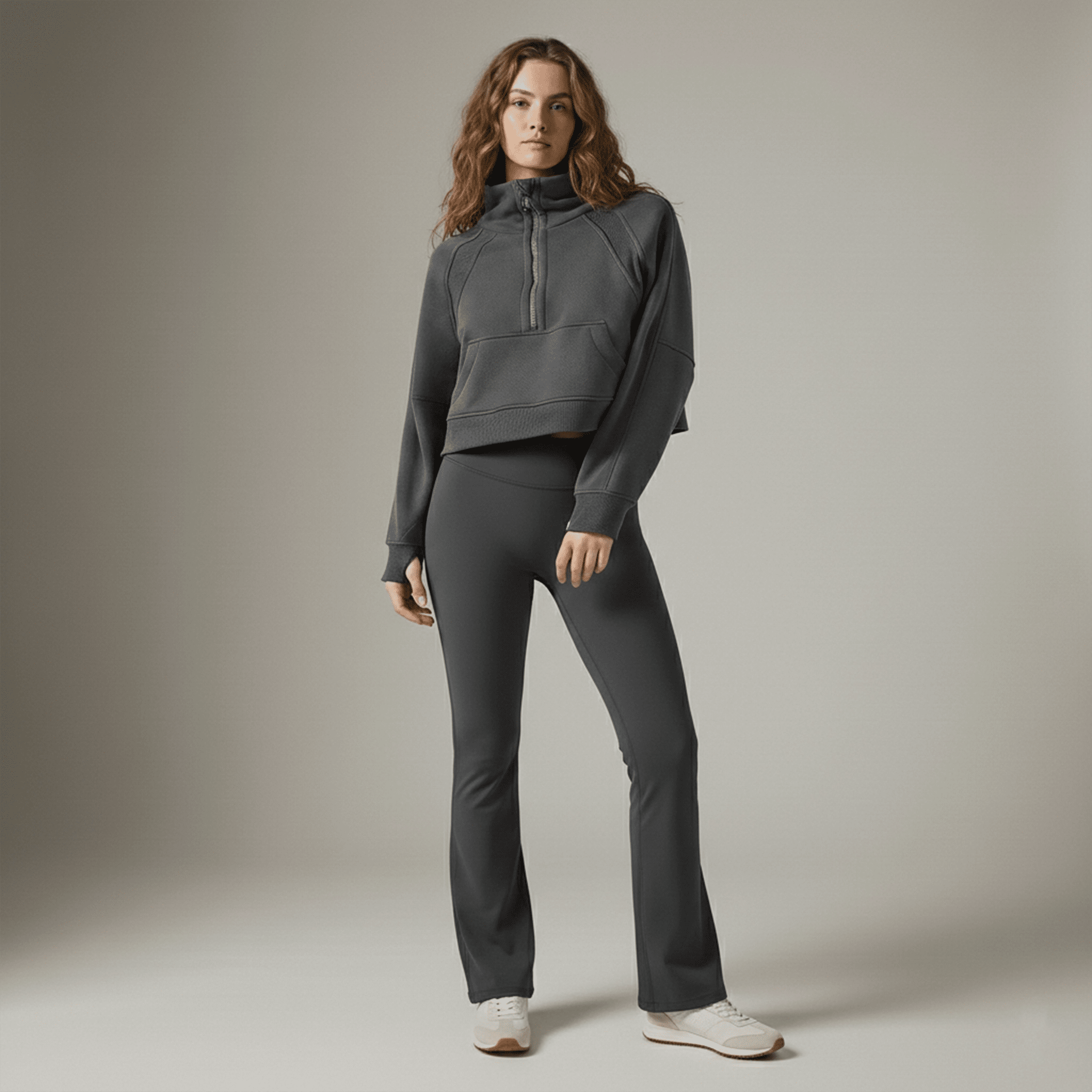 Woman wearing a gray tracksuit against a neutral background