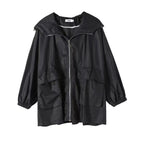 A black lightweight hooded raincoat with a front zipper, elasticized cuffs, and large front pockets, shown against a plain white background.