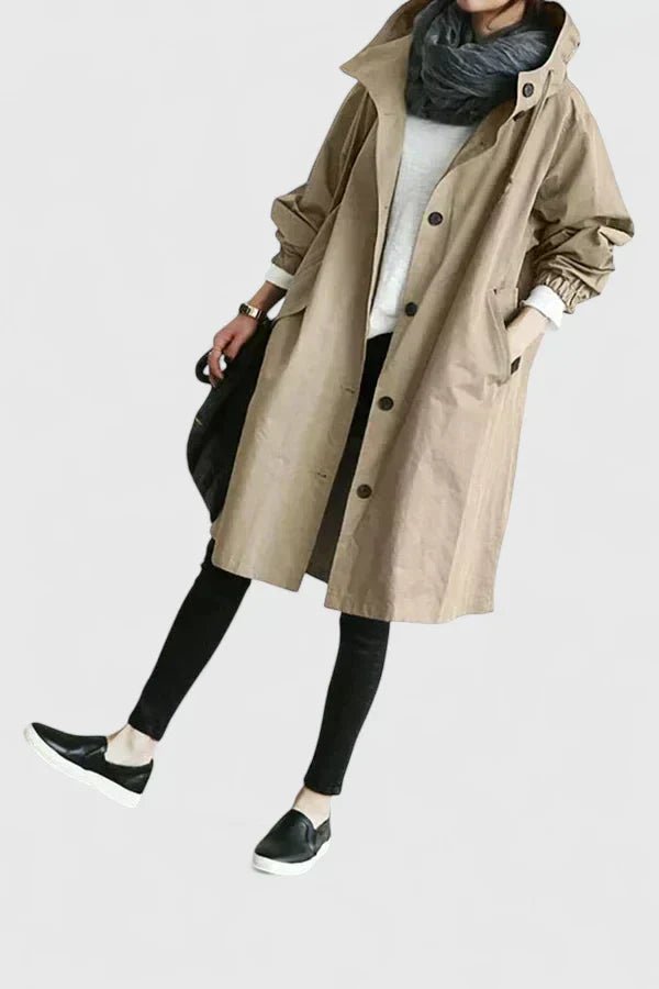 Person wearing a beige trench coat on a white background