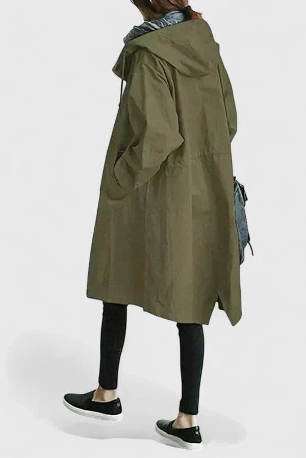 Person wearing a long green coat on a white background