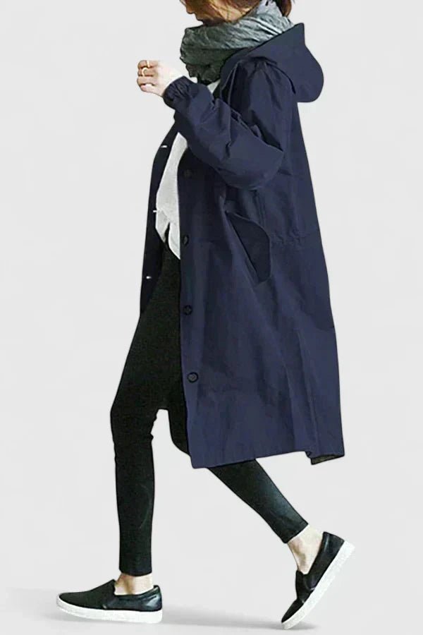 Person wearing a navy blue coat on a plain background