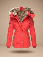 A bright red puffer jacket with a plush brown faux-fur trimmed hood, displayed on a neutral beige background.