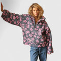 Person wearing a gray floral-patterned sweater on a plain background