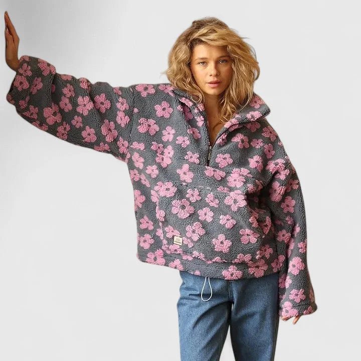Person wearing a gray floral-patterned sweater on a plain background