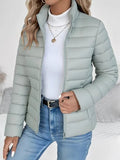 Light blue puffer jacket worn by a person on a neutral background
