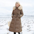 Woman wearing a long brown puffer coat with fur hood in a snowy landscape