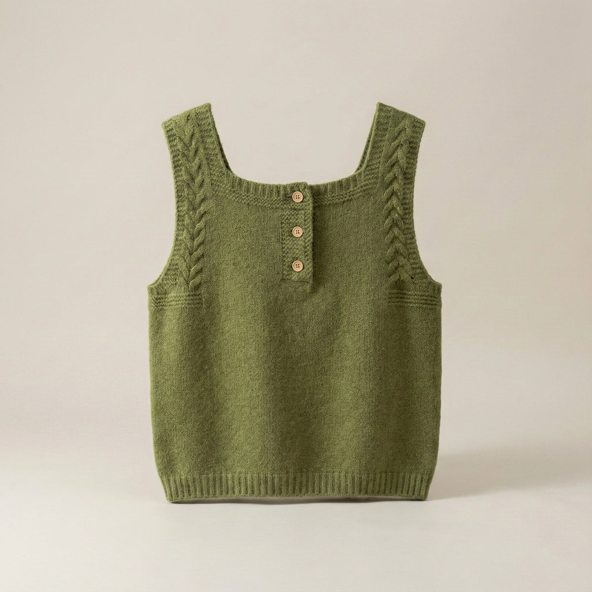 Green knitted tank top with button details on a beige background