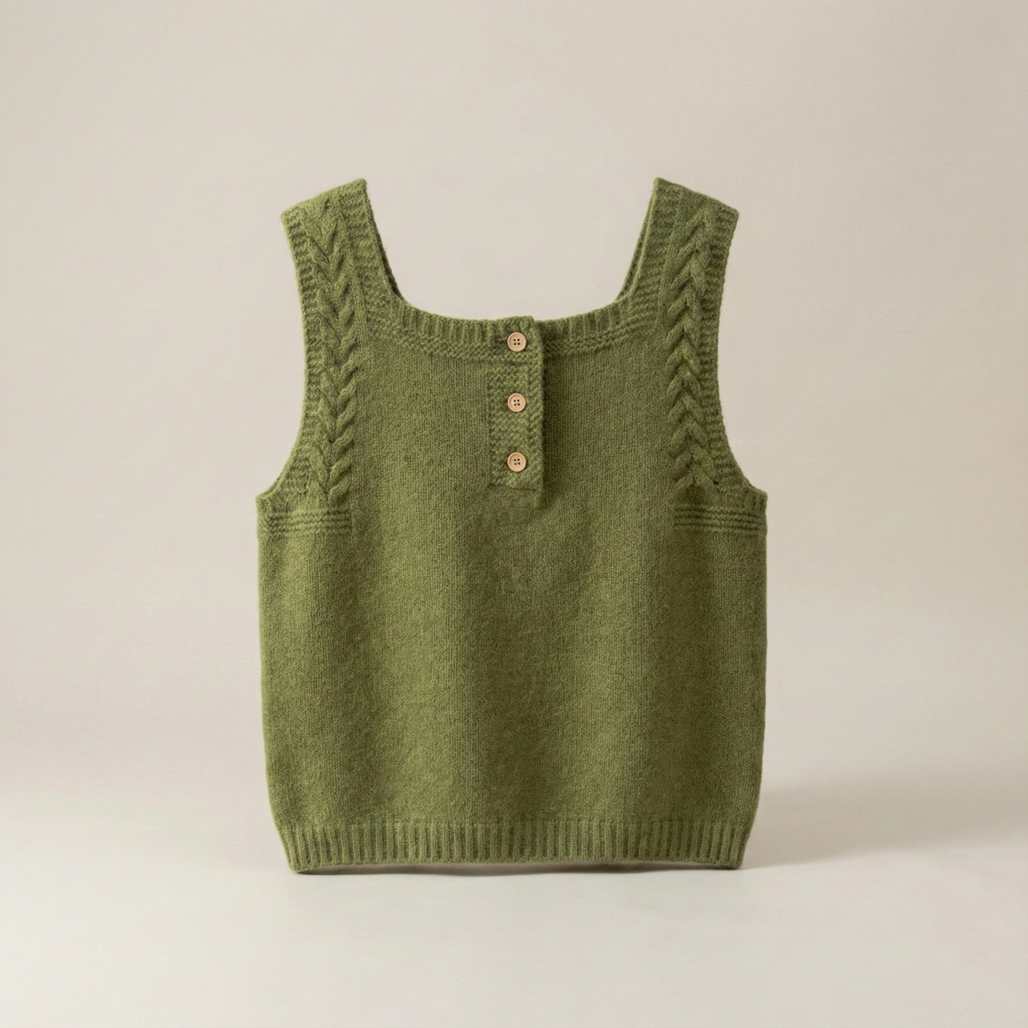 Green knitted tank top with button details on a beige background
