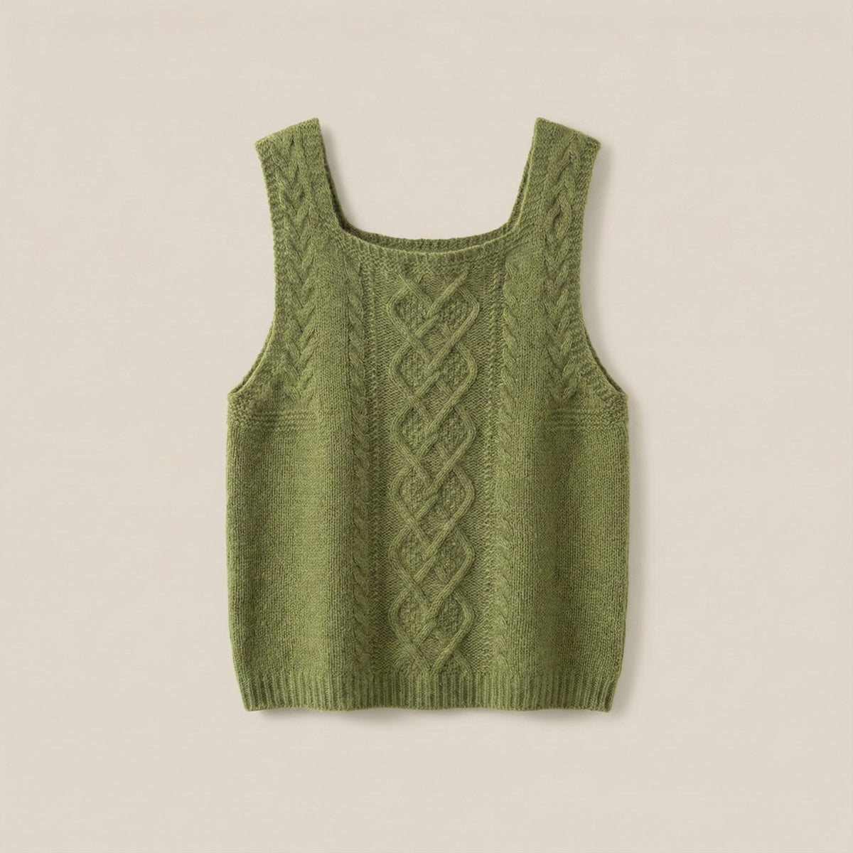 Green knitted tank top with cable pattern on a beige background