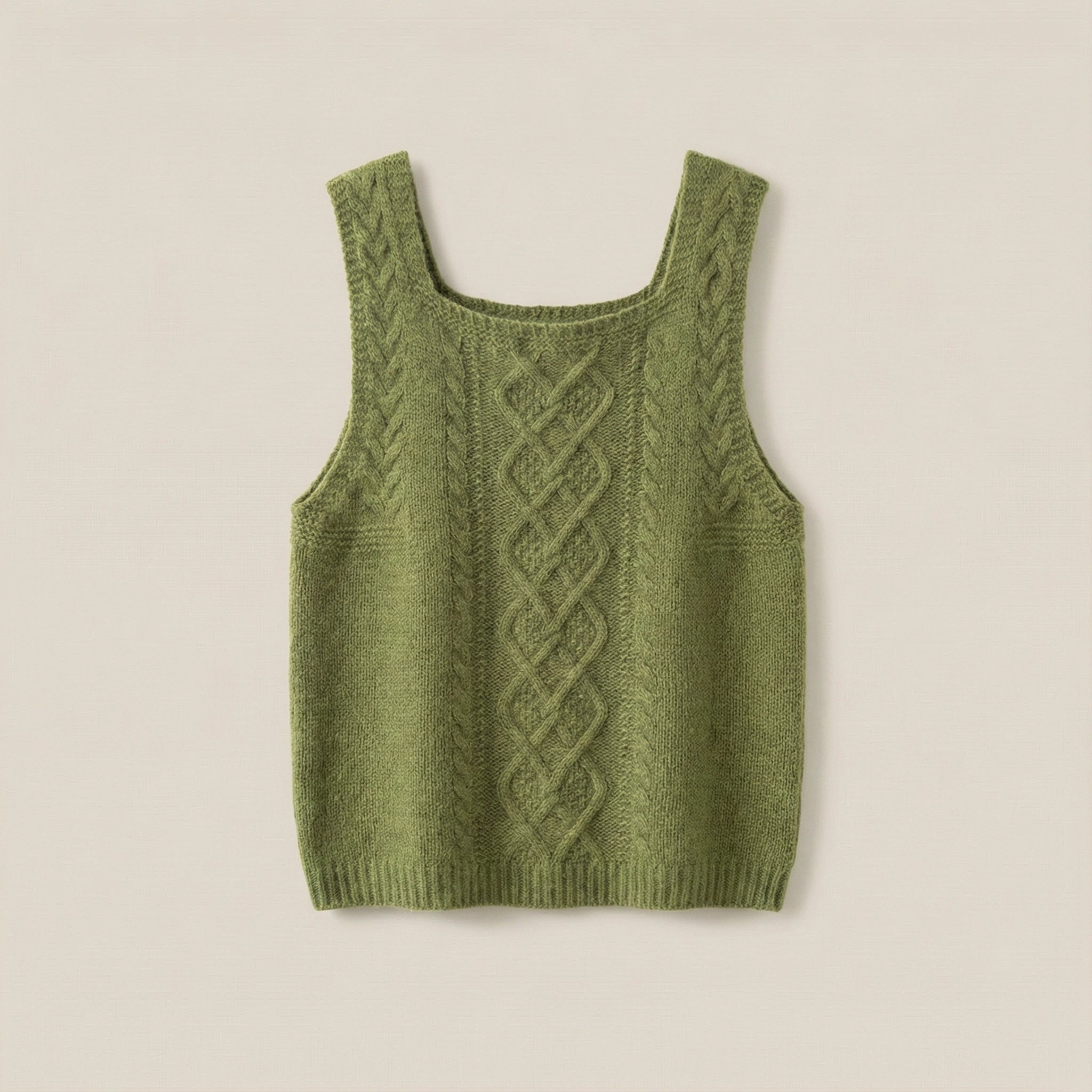 Green knitted tank top with cable pattern on a beige background