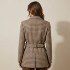 Woman wearing a plaid blazer against a beige background