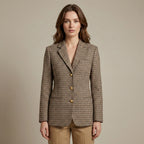 Woman wearing a checkered blazer with gold buttons on a beige background