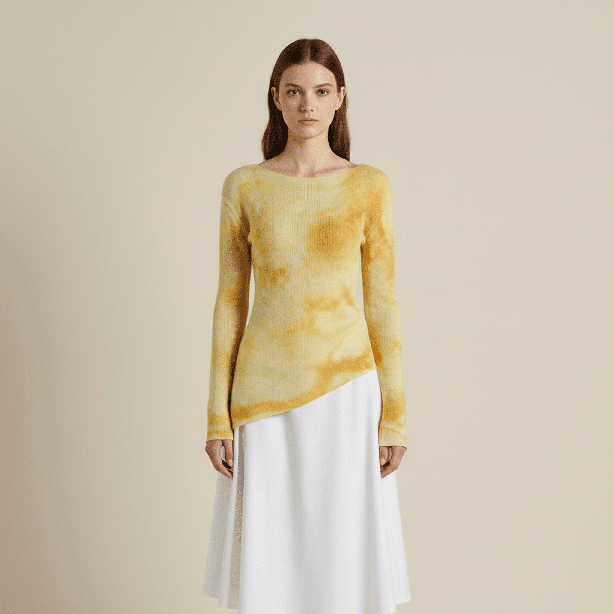 Woman wearing a yellow tie-dye sweater and white skirt on a beige background