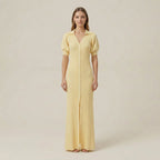 Woman wearing a yellow dress against a plain background