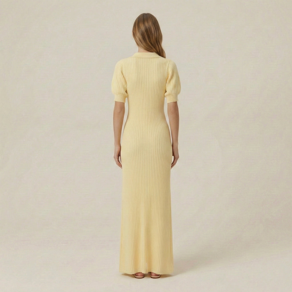 Woman wearing a long yellow dress with a plain background