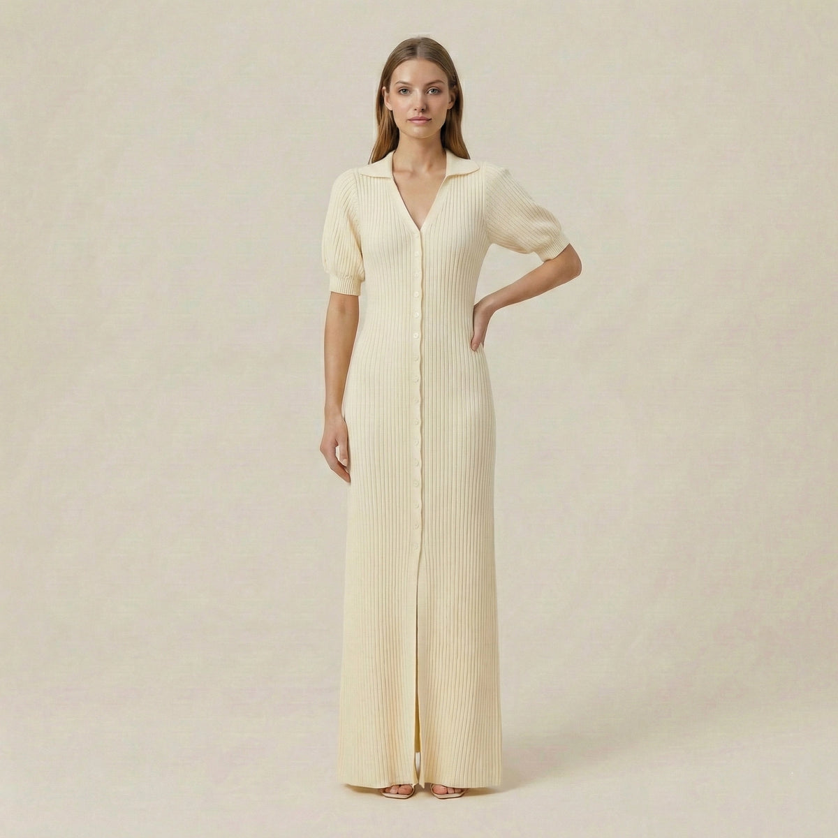 Woman wearing a long, light-colored dress against a plain background