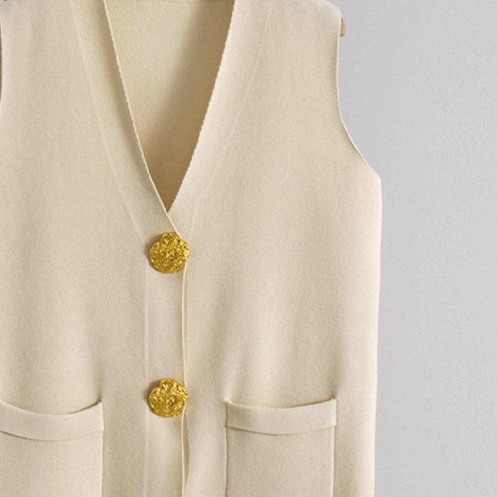 Beige vest and wide-leg pants on hangers against a gray background