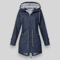 A navy blue hooded raincoat with silver zippers and white-and-black striped lining inside the hood, shown against a solid gray background.